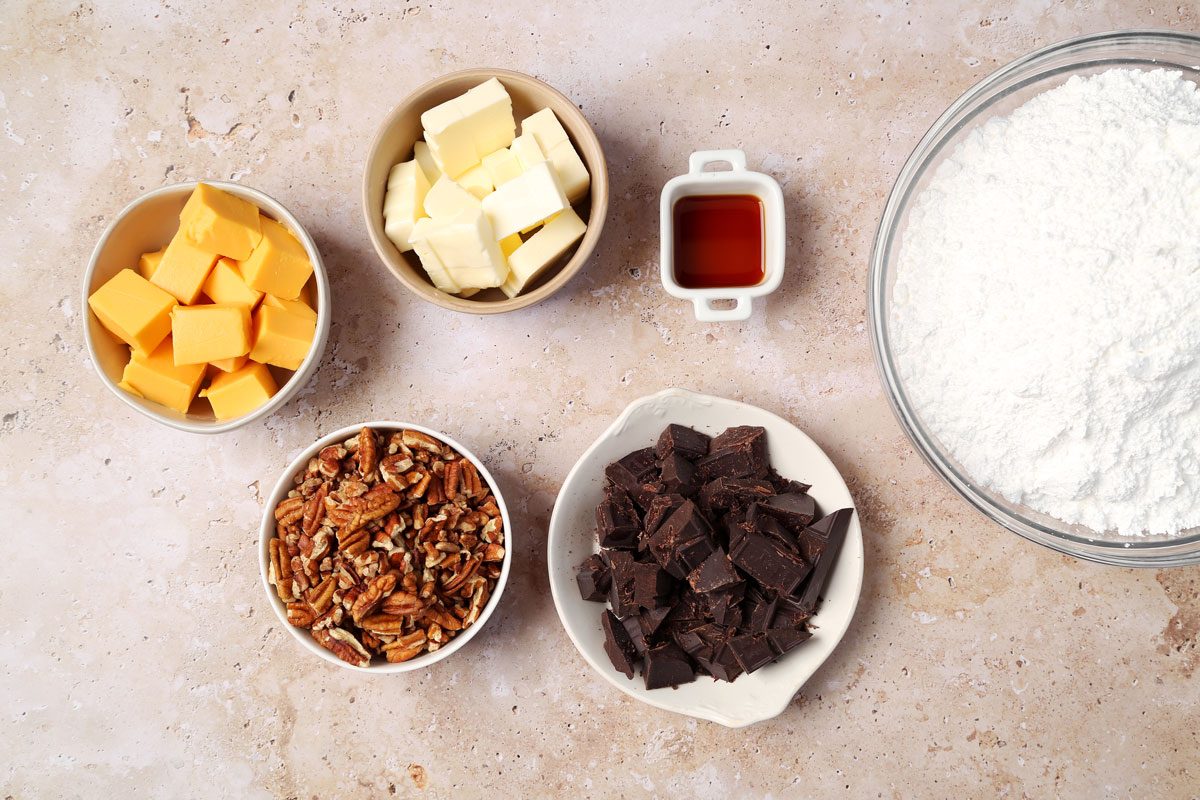 Ingredients for Taste of Home's Velveeta Fudge laid out in small bowls on brown marble surface.