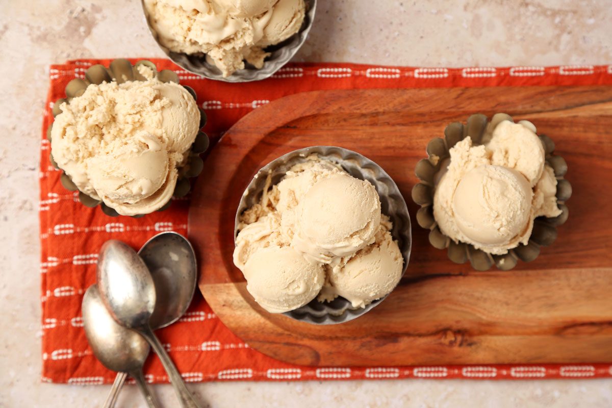 Close up of Taste of Home's Peanut Butter Ice Cream served in small metal bowls on a brown marble surface.