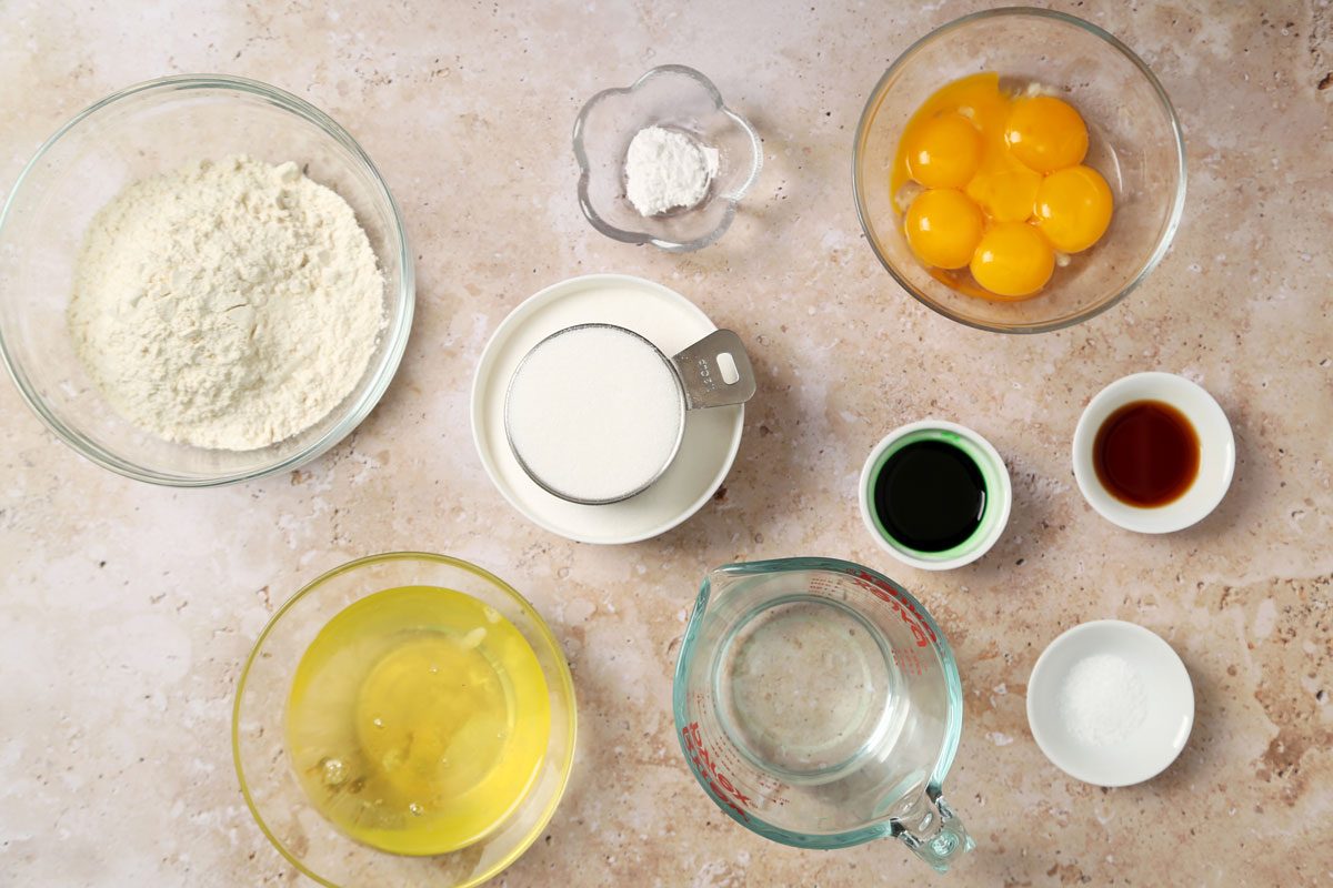 Ingredients for Taste of Home's Pandan Cake laid out in small bowls on a brown marble surface.