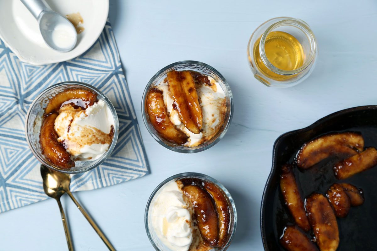 Process of making Taste of Home's bananas foster laid out on a light blue surface with a blue linen.