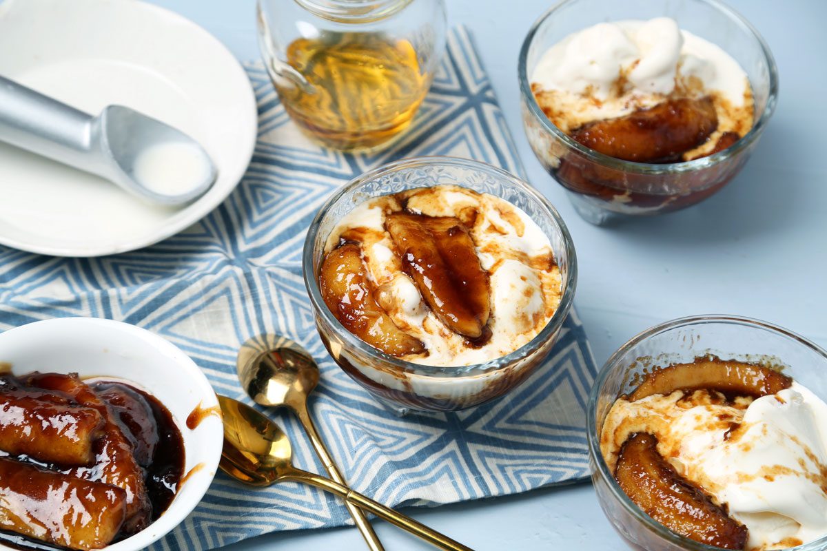 Close up of Taste of Home's bananas foster laid out on a light blue surface with a blue linen.