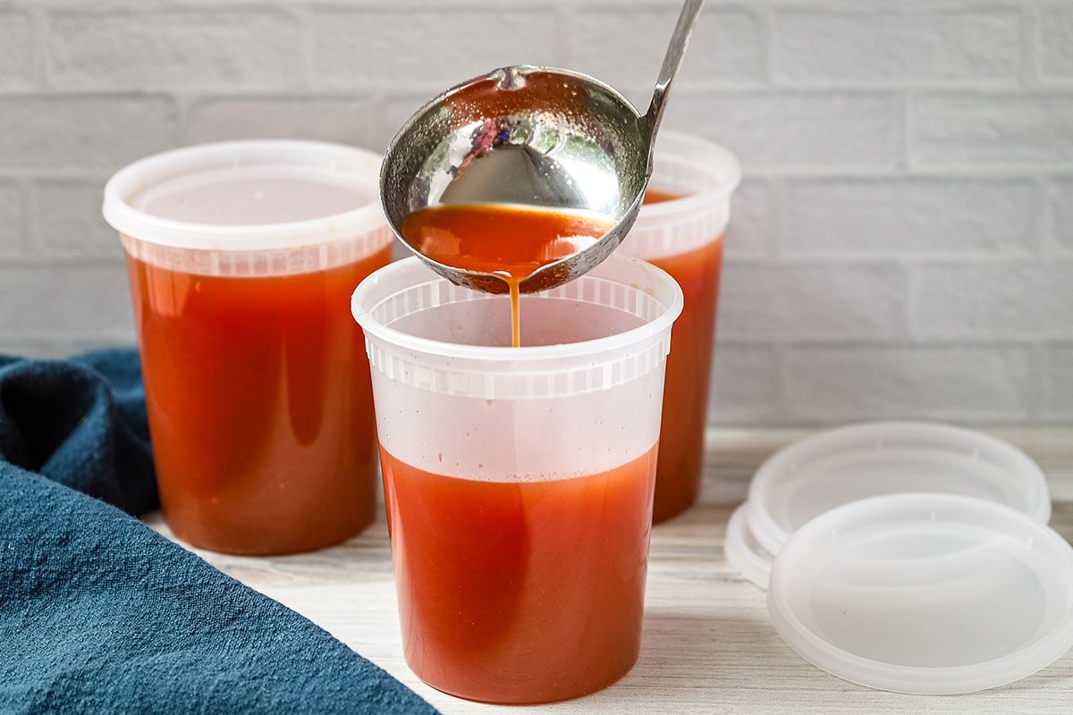 Pouring homemade spicy tomato juice into 1-quart containers, a recipe from Taste of Home.