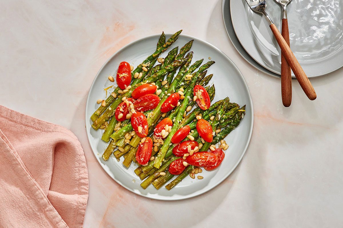 Baked asparagus and tomatoes on a serving plate
