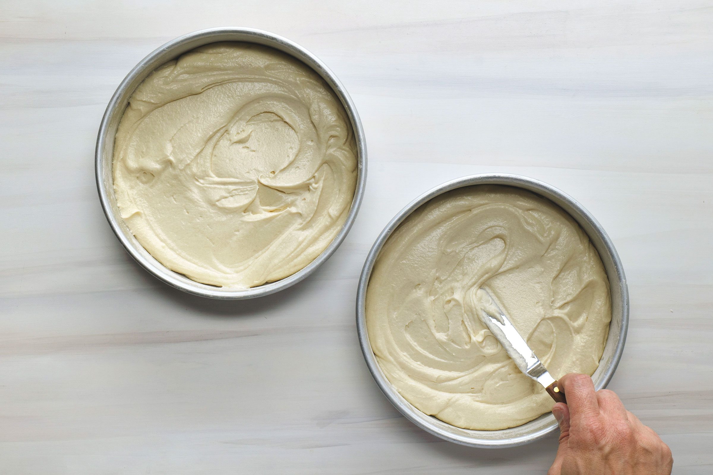 Cake batter divided in two cake pans 