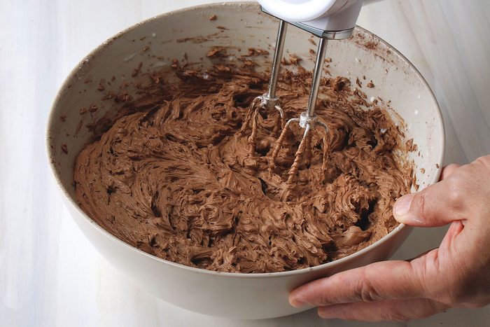Mixing cocoa and sugar in creamy butter