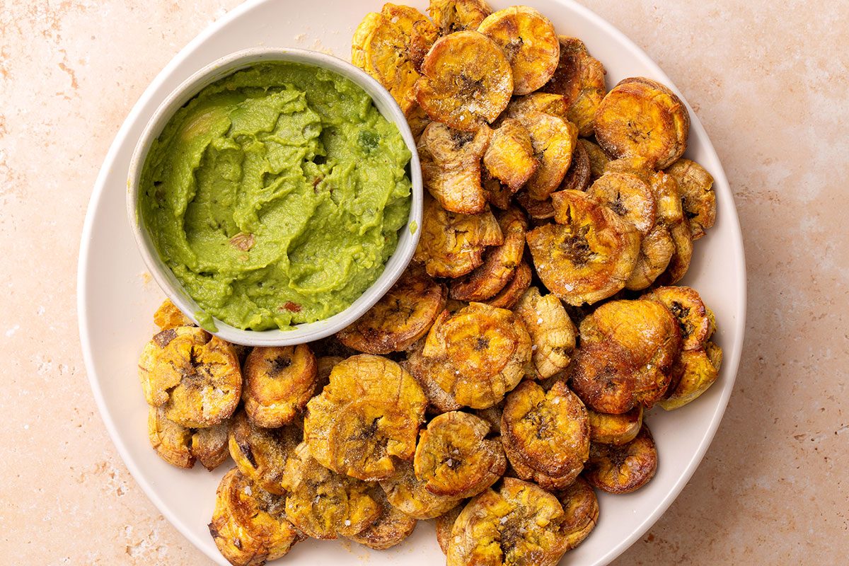 Sliced and seasoned Air-Fryer Plantains on a plate with guacamole dip for Taste of Home