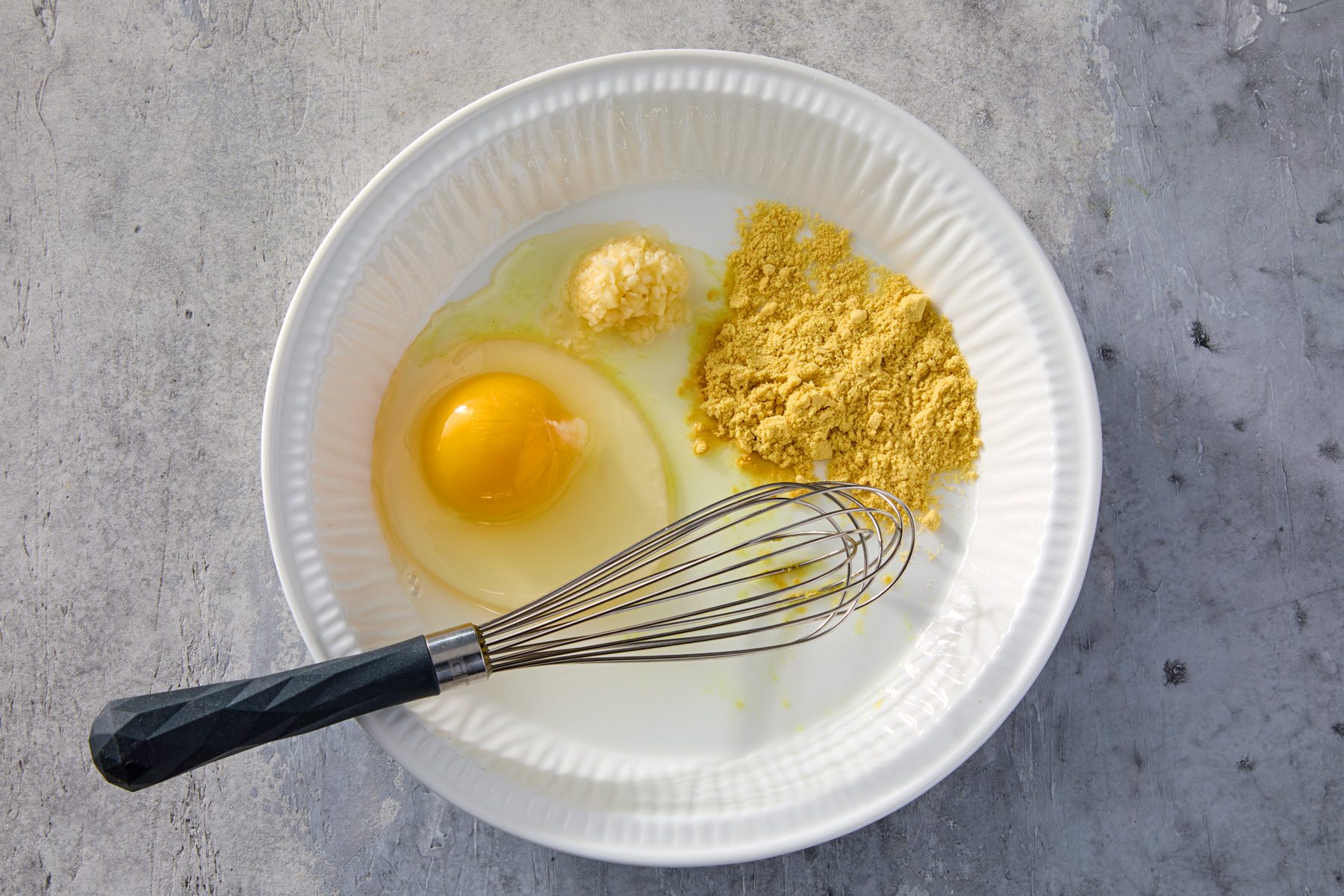 In a shallow bowl, whisk together egg substitute, mustard and garlic.