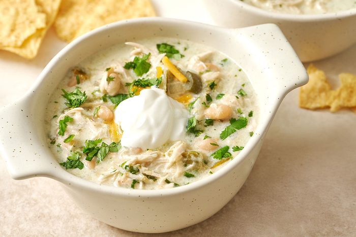Close-up horizontal shot of the Taste of Home Green Chicken Chili, highlighting the creamy texture, shredded chicken, and navy beans.