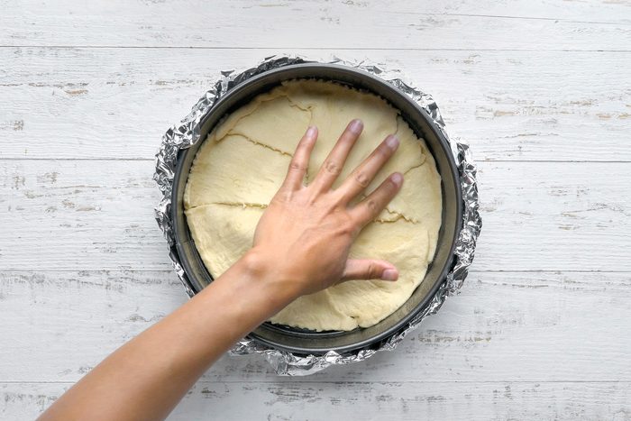 Press dough onto bottom of prepared pan to form a crust, sealing seams well.