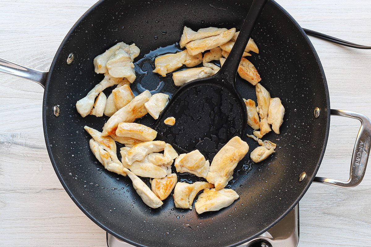 Stir-frying chicken for a homemade peanut chicken stir-fry recipe.