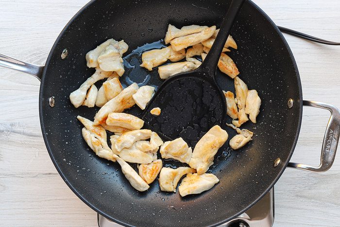 Stir-frying chicken for a homemade peanut chicken stir-fry recipe.