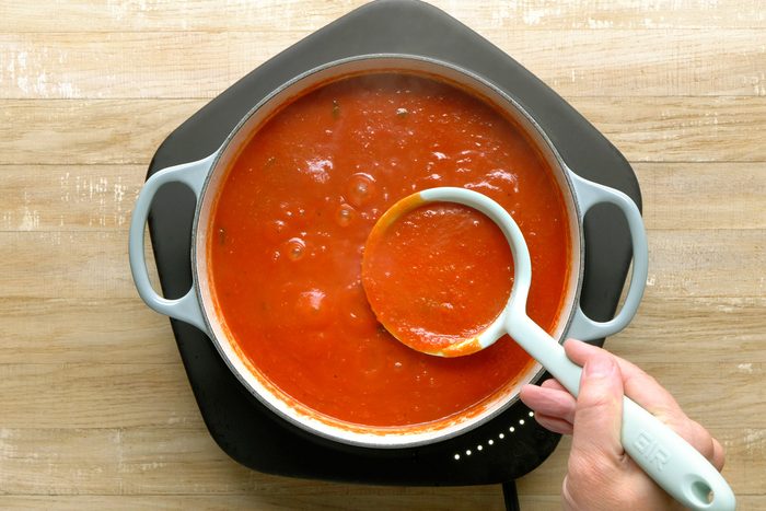 Crushed tomatoes, water, tomato paste, salt, and chopped basil combined in a Dutch oven and brought to a boil.