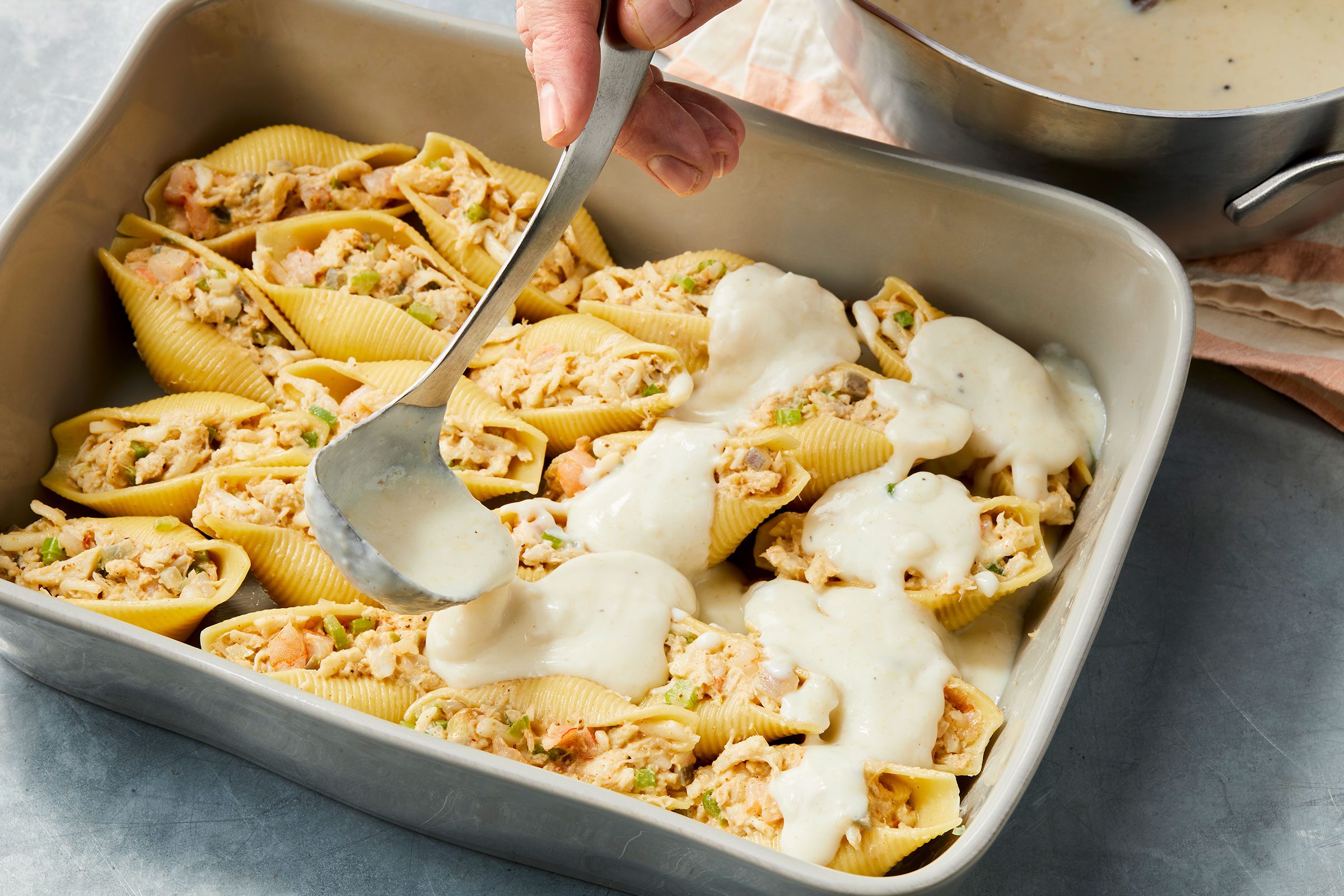 Pouring cream over stuffed pasta shells