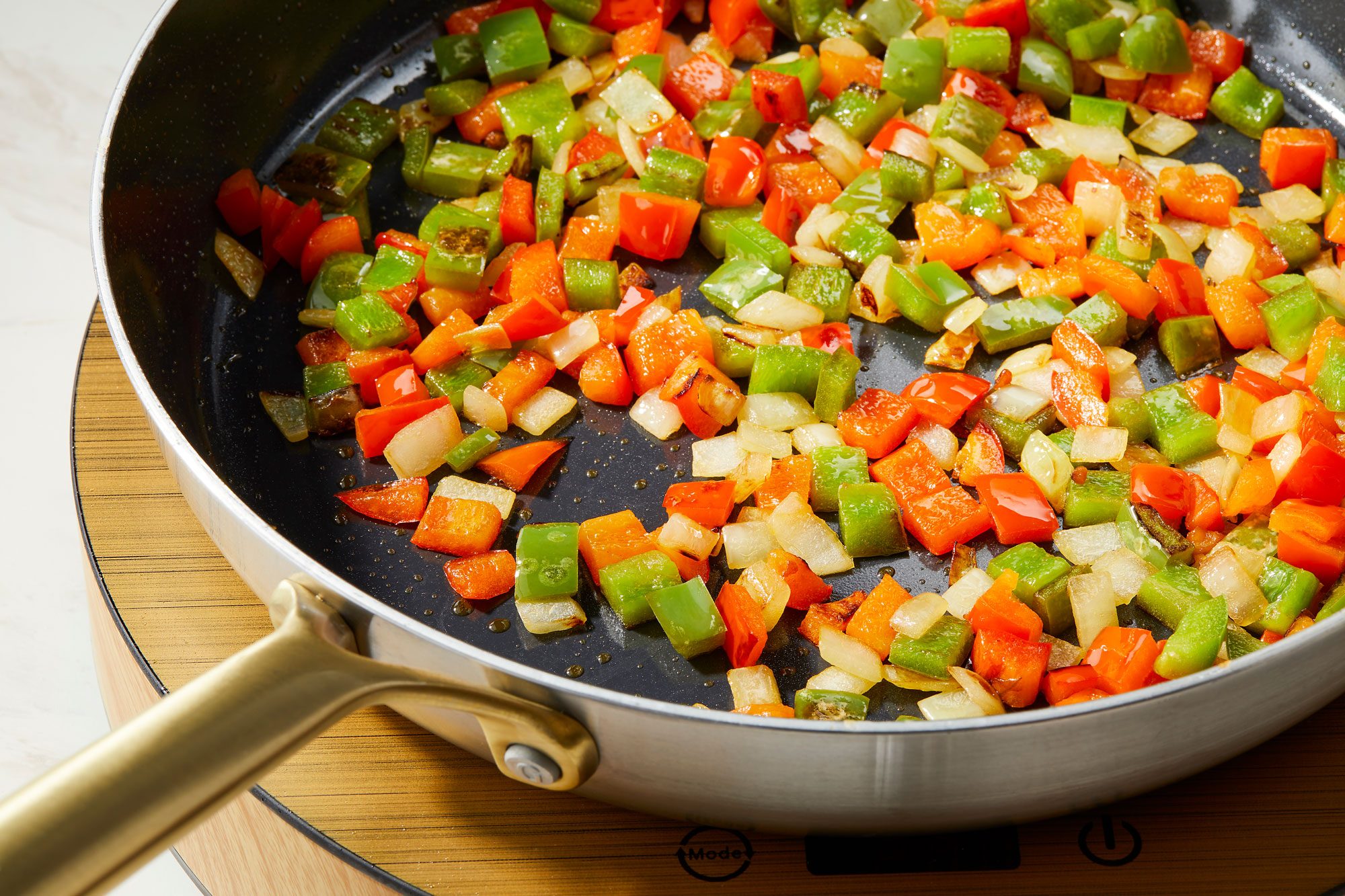 Heating 2 tablespoons oil in the hot skillet or wok, Added bell peppers and onion then cook until crisp tender