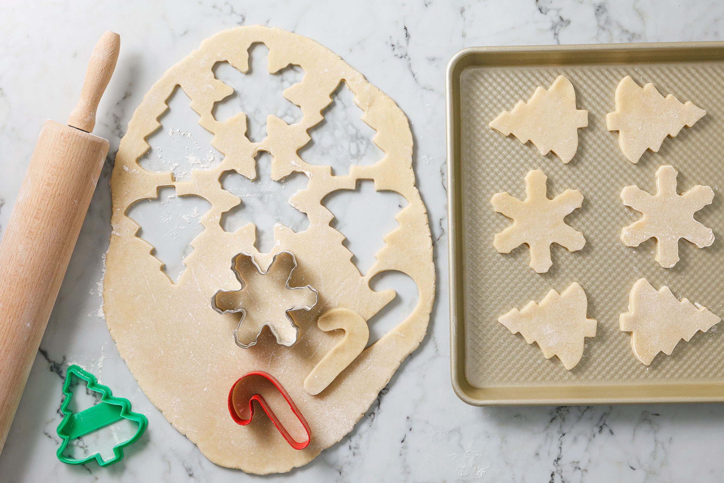 Cutting cookie dough using Christmas themed cookie cutter