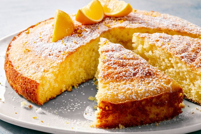Lemon Olive Oil Cake Bake with lemon slices on it and cut into wedges