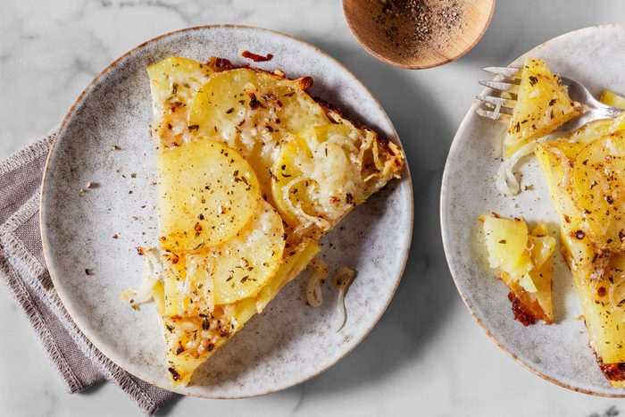Baked potato galette sliced into wedges and served on a plate