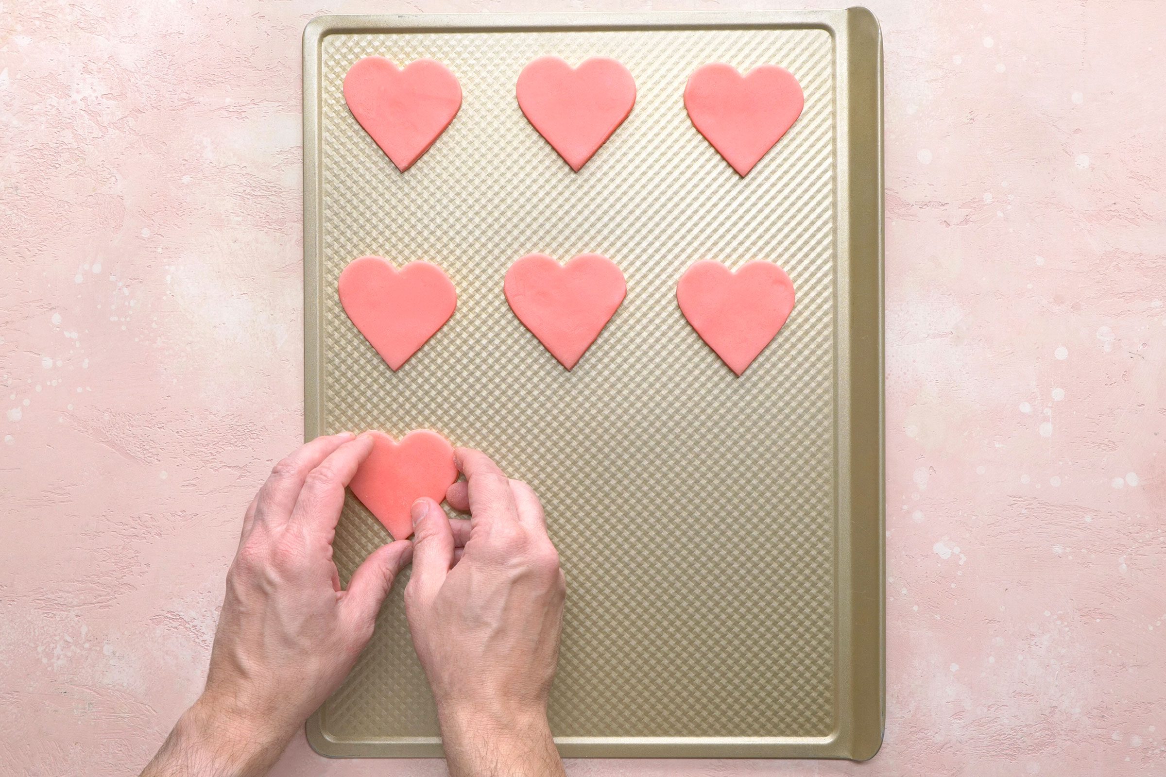 Heart shaped cookie dough placed on an non greased baking sheet