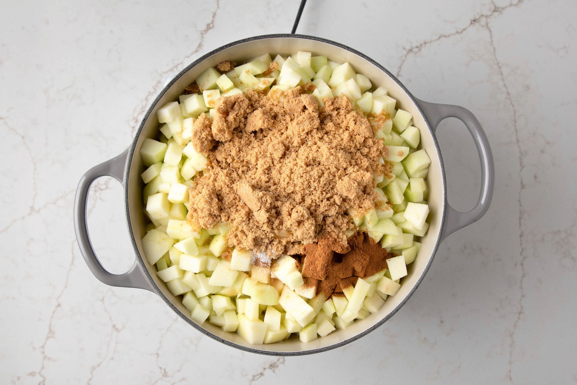 The pot is filled with diced apples, brown sugar, and cinnamon
