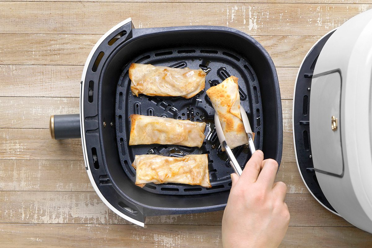 Apple Pie Egg Rolls being turned over in air fryer