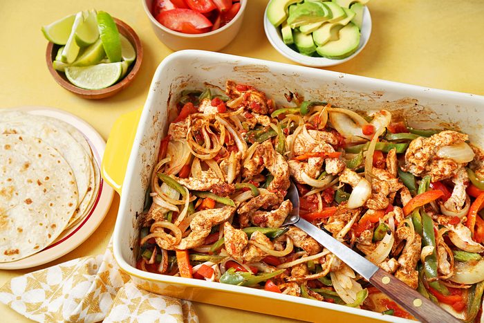 Baked Chicken and vegetables in a dish with tortillas on side