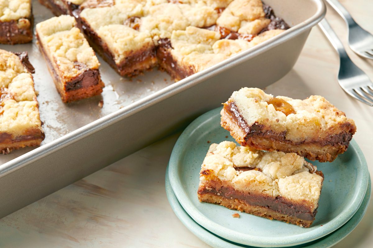 Caramel Bars on a small plate next to a baking dish containing more bars