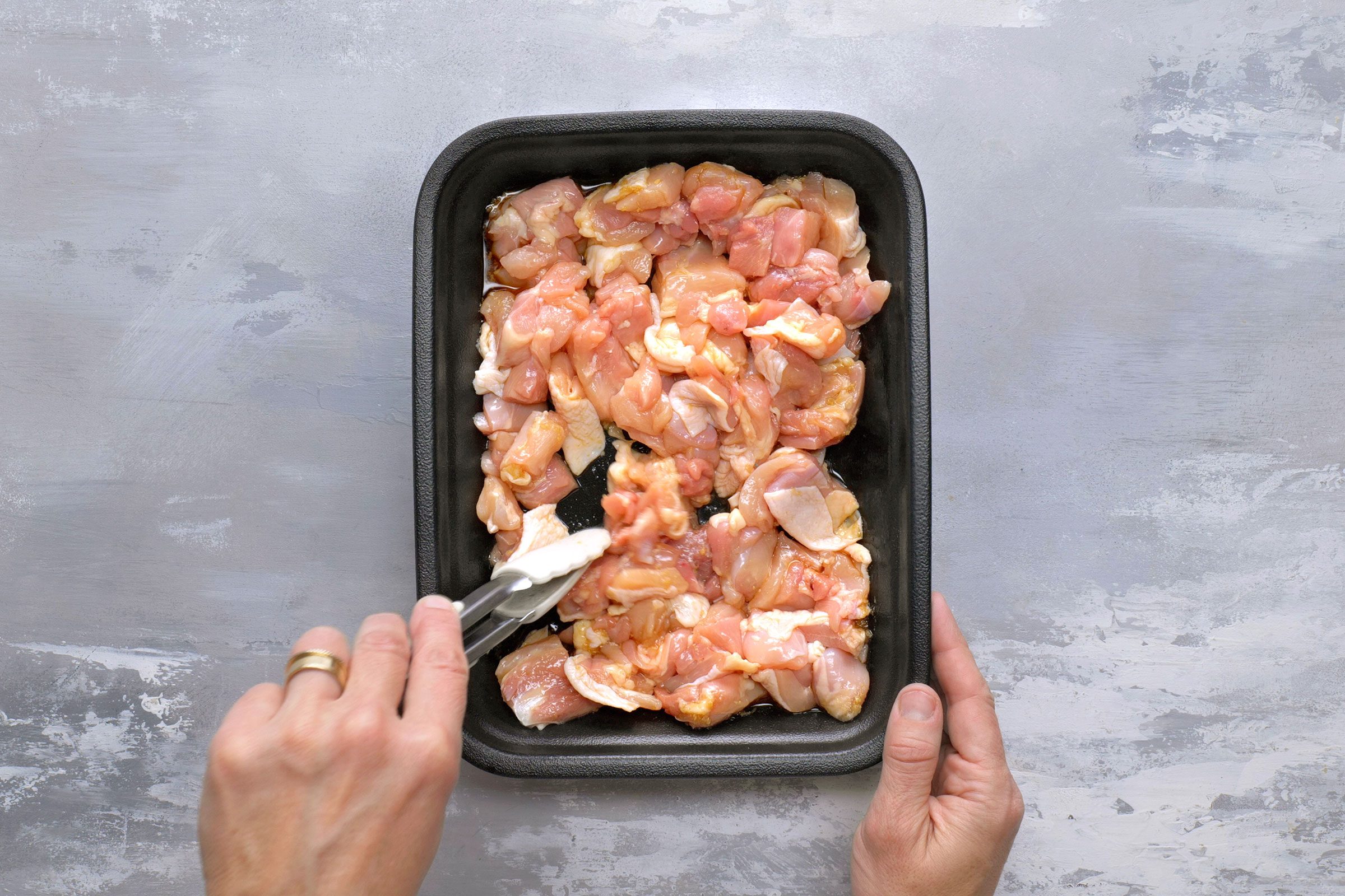 Deboned chicken cut into pieces and placed in a container