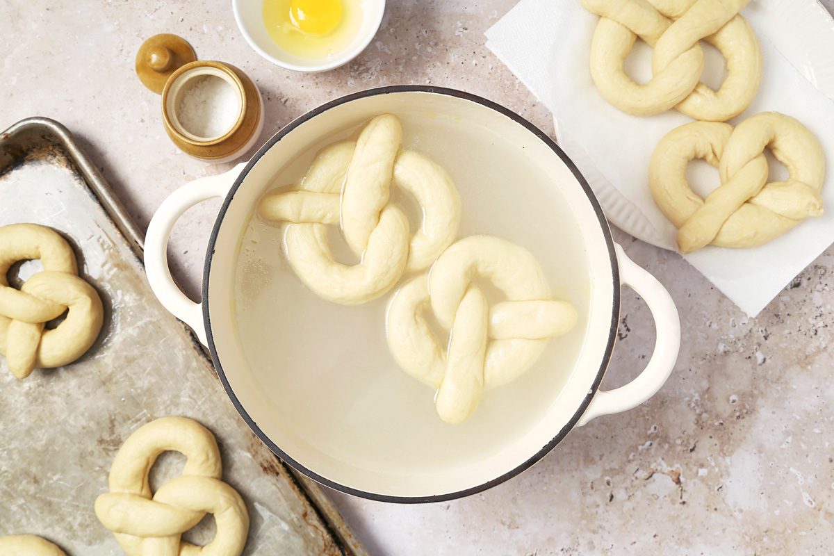 two pretzels being boiled in a dutch oven