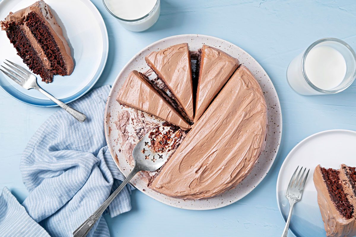 Vegan chocolate cake sliced and served on blue plates.