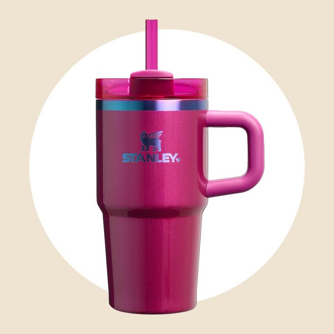 Shiny magenta Stanley tumbler on a tan and white background