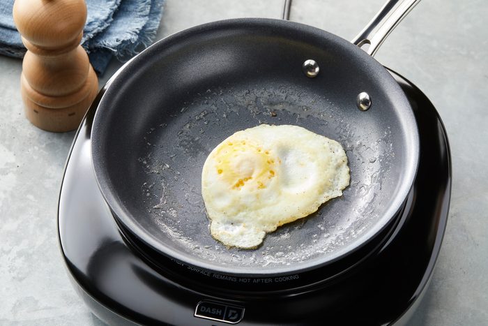 3/4 ang;e view shot of Flip egg; cook 30-60 seconds or until whites are fully set and yolks are still runny; induction; napkin; grey surface;