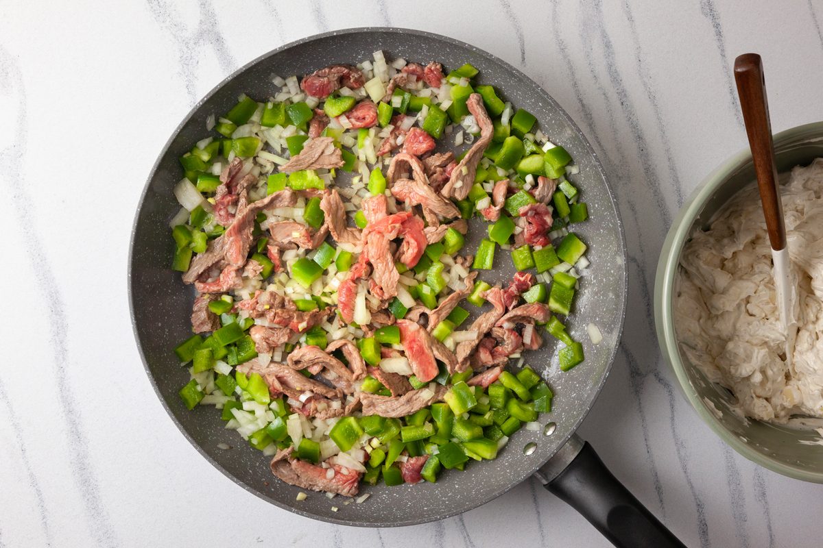 Cooking steak and vegetables in a large skillet