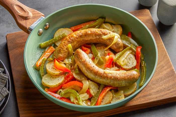 Sausage And Potato Skillet placed on a wooden board