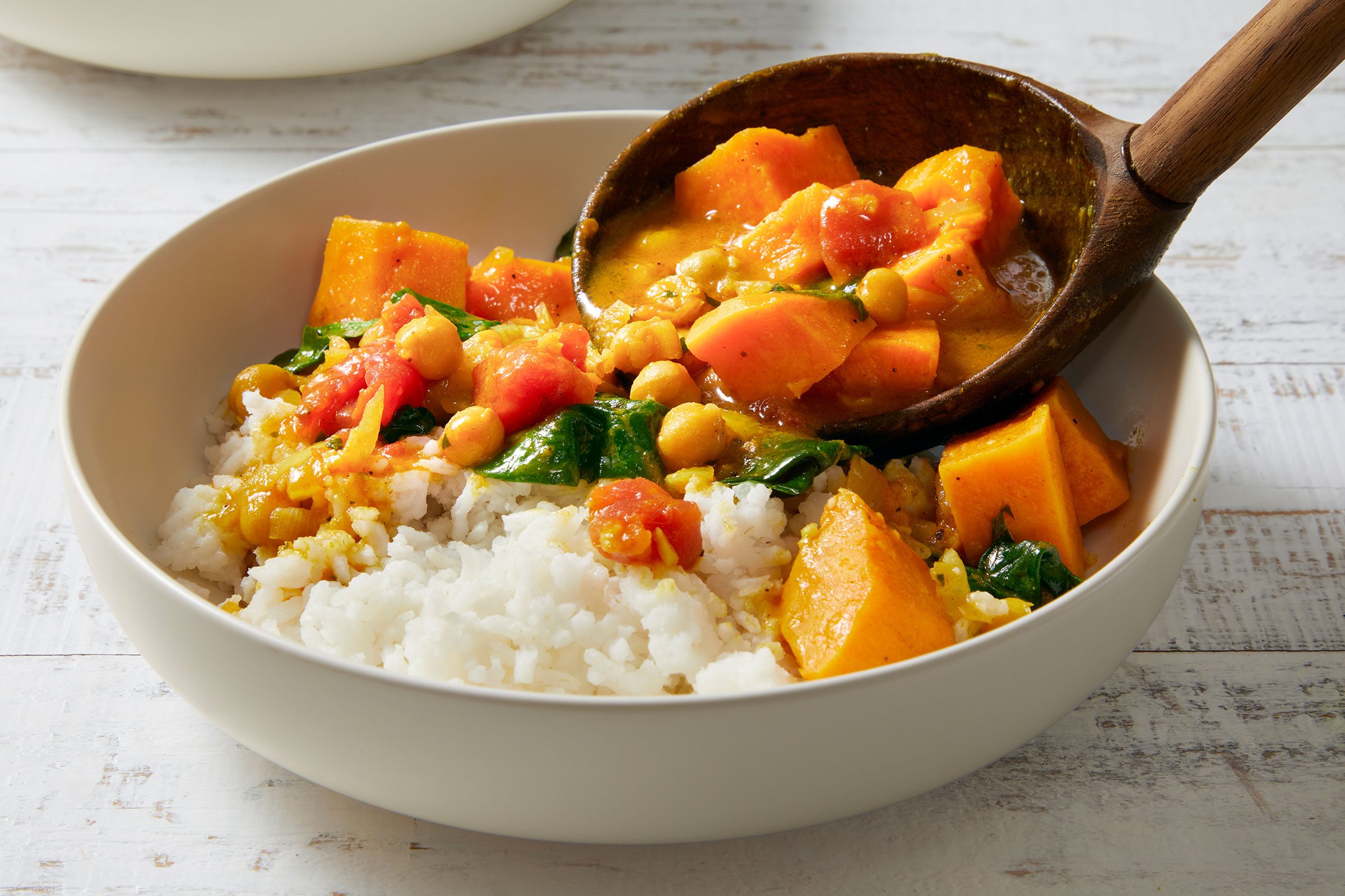 Sweet Potato Curry poured on rice in a bowl