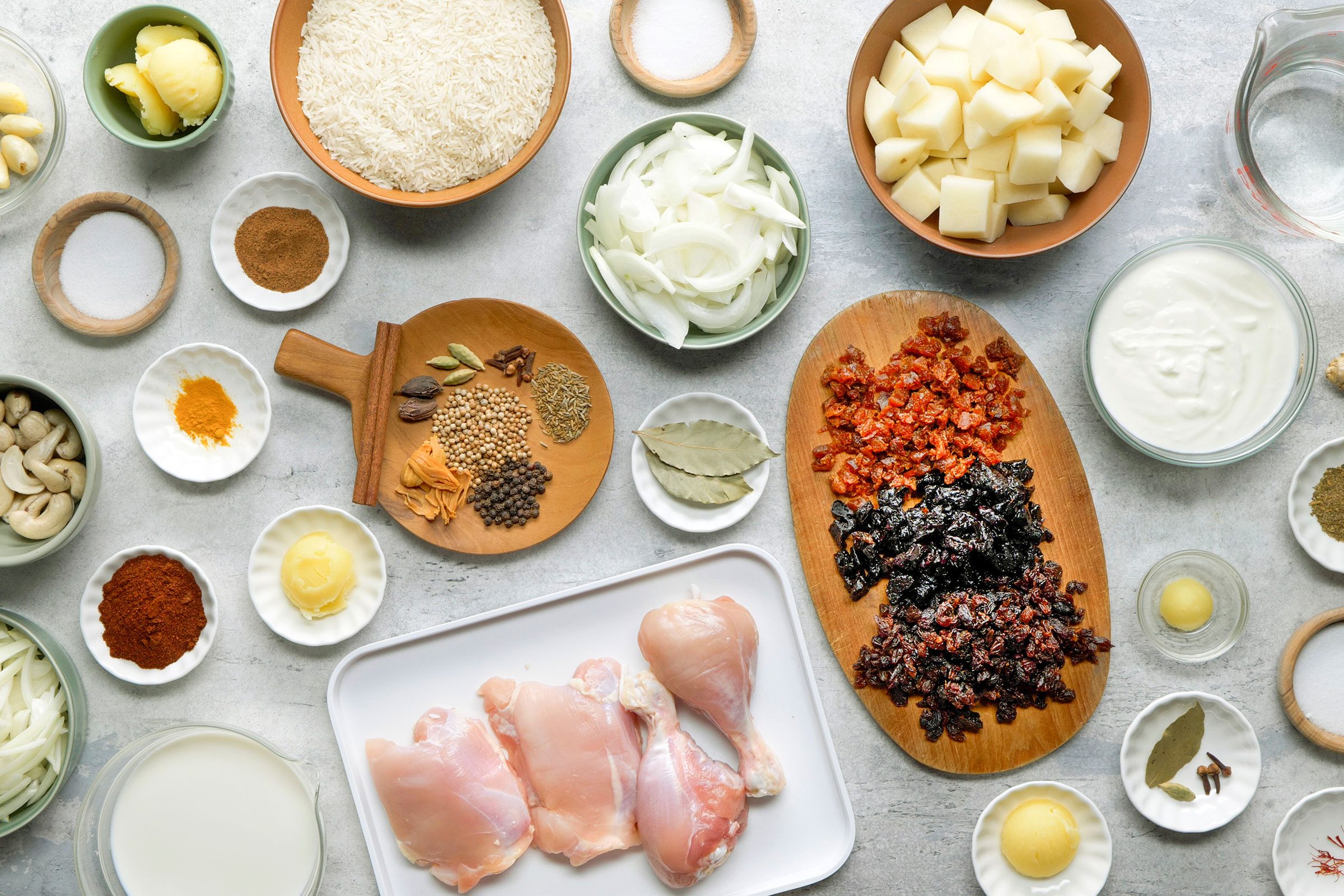 Ingredients for Chicken Biryani on plates and in small bowls