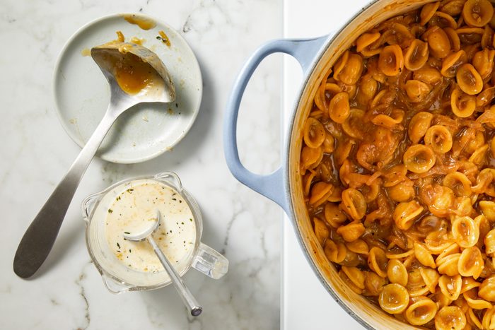 The pasta absorbs the beef stock as it cooks; once absorbed, a splash of beef stock is added. Continue simmering and adding more stock gradually until the orecchiette reaches al dente, about 10 to 13 minutes.