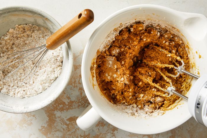 Oats, flour, baking soda, cinnamon, nutmeg and salt in a bowl with another bowl of dry and wet mixture beaten together