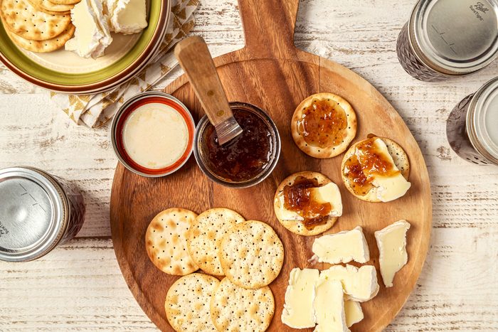 Onion Jam served on a wooden board with crackers and cheese