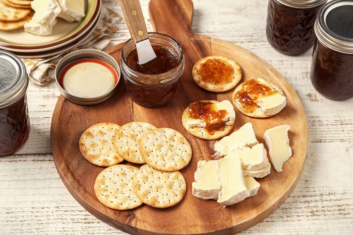 Onion Jam served on a wooden board with crackers and cheese