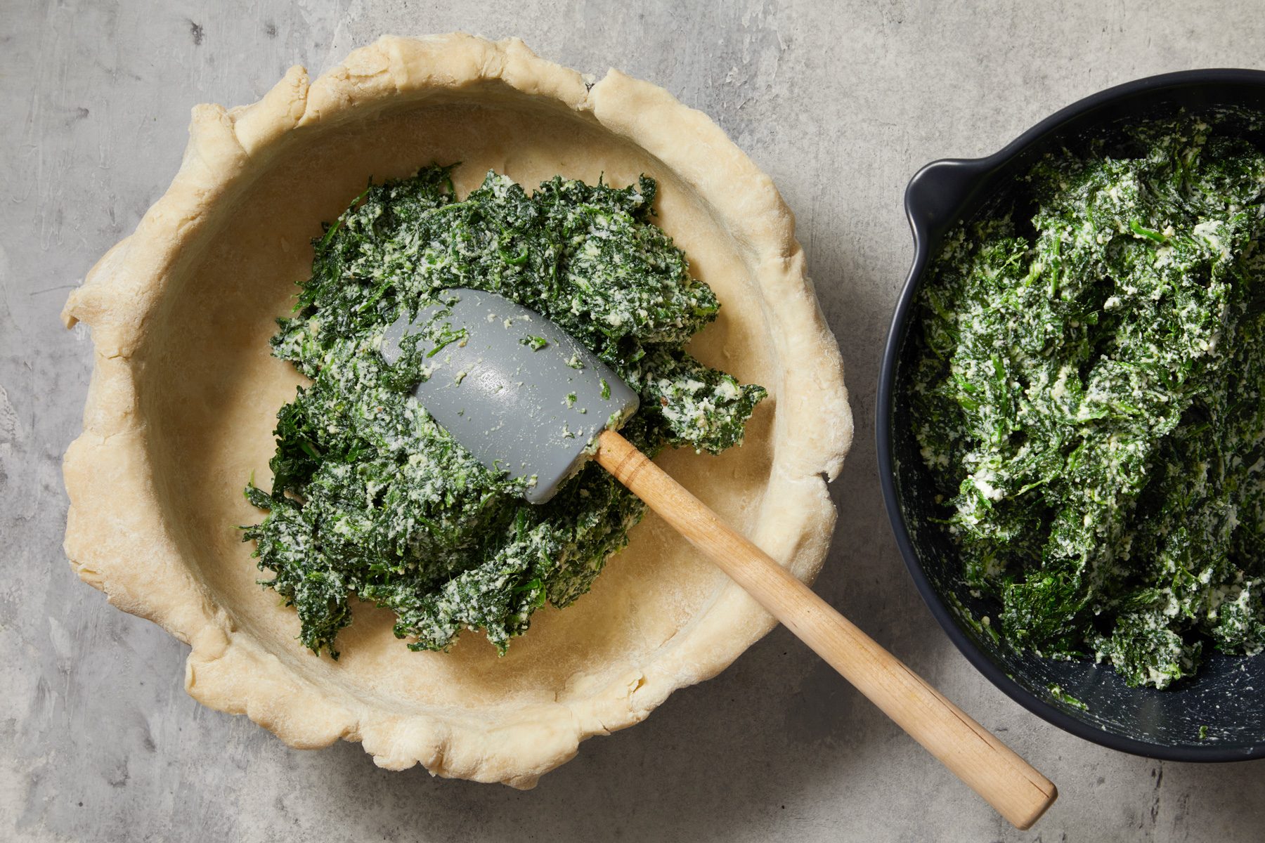 Overhead shot of spoon into crust; spatula; marble surface;