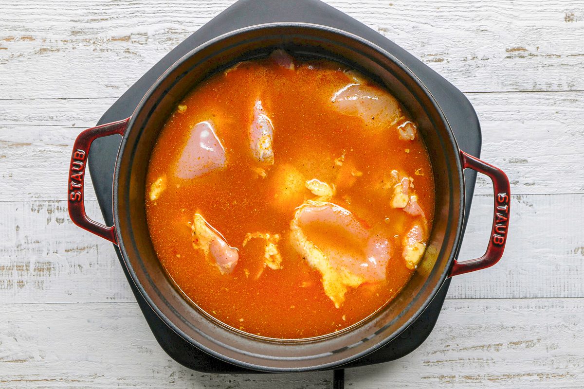 chicken added to curry mixture in dutch oven