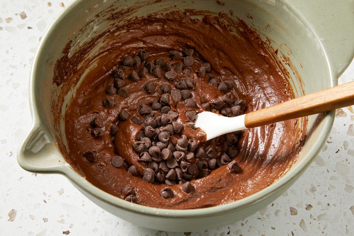 Close shot of fold in chocolate chips; spatula; marble surface;