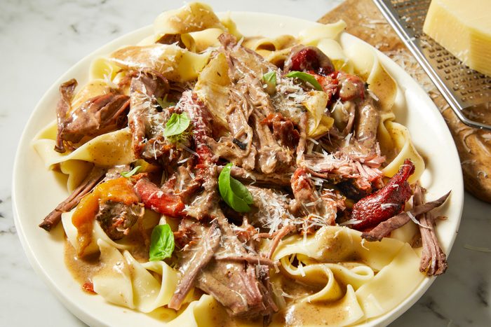 Marry Me Pot Roast served on plates on a marble countertop,