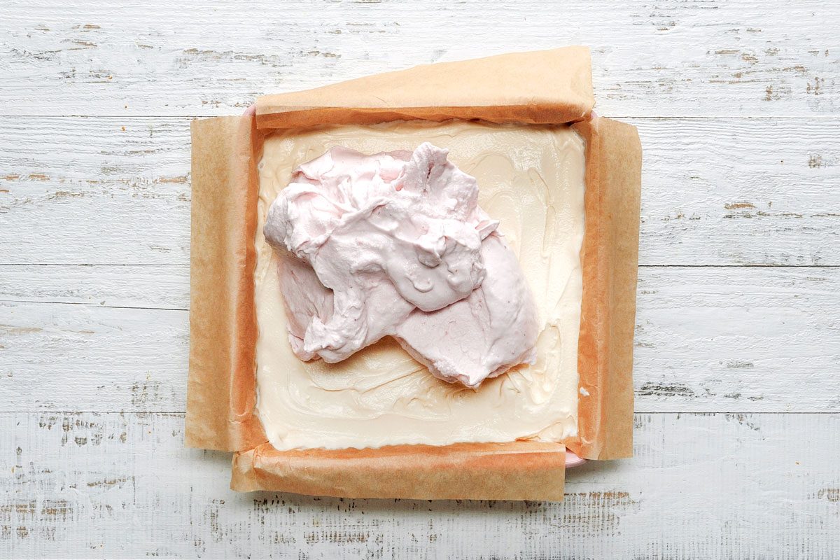 Overhead shot of spread with strawberry ice cream; white wooden surface;