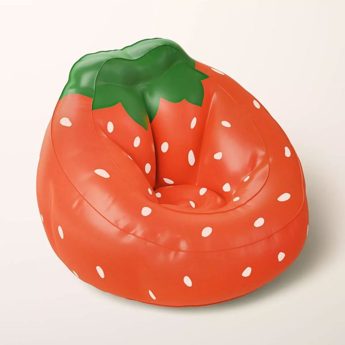 Kate Spade inflatable strawberry chair on a tan background