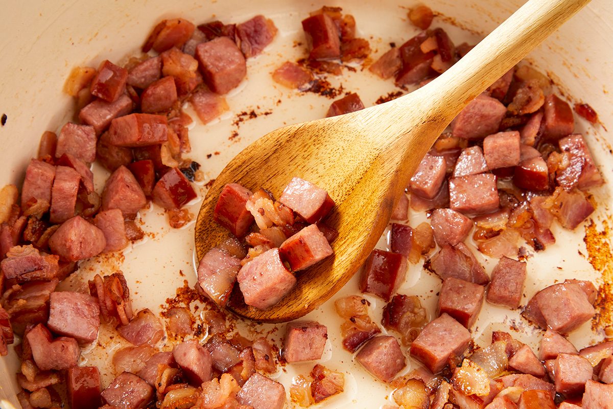 dd bacon and smoked sausage; cook until bacon is crisp