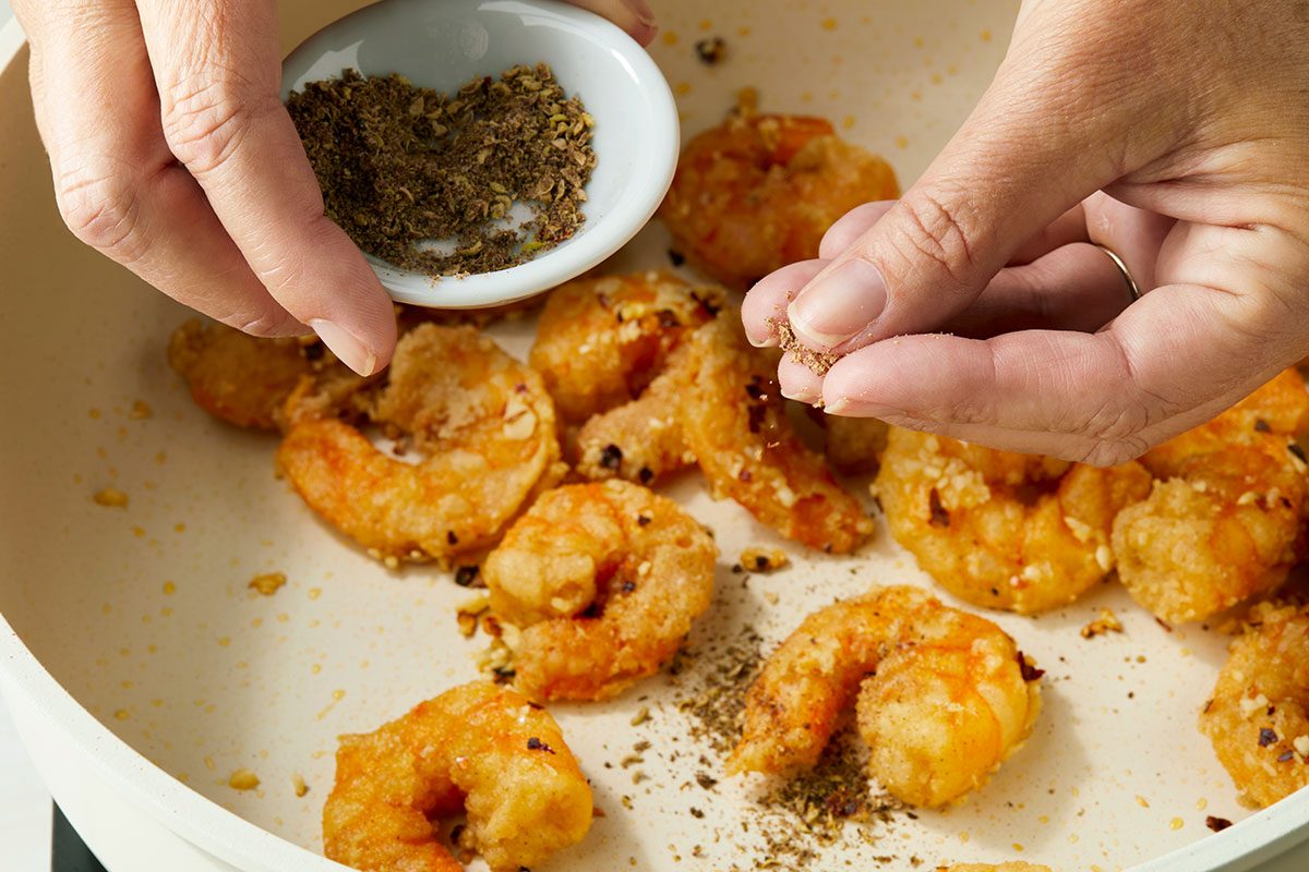 Toasted Sichuan Peppercorns being sprinkled on a dish
