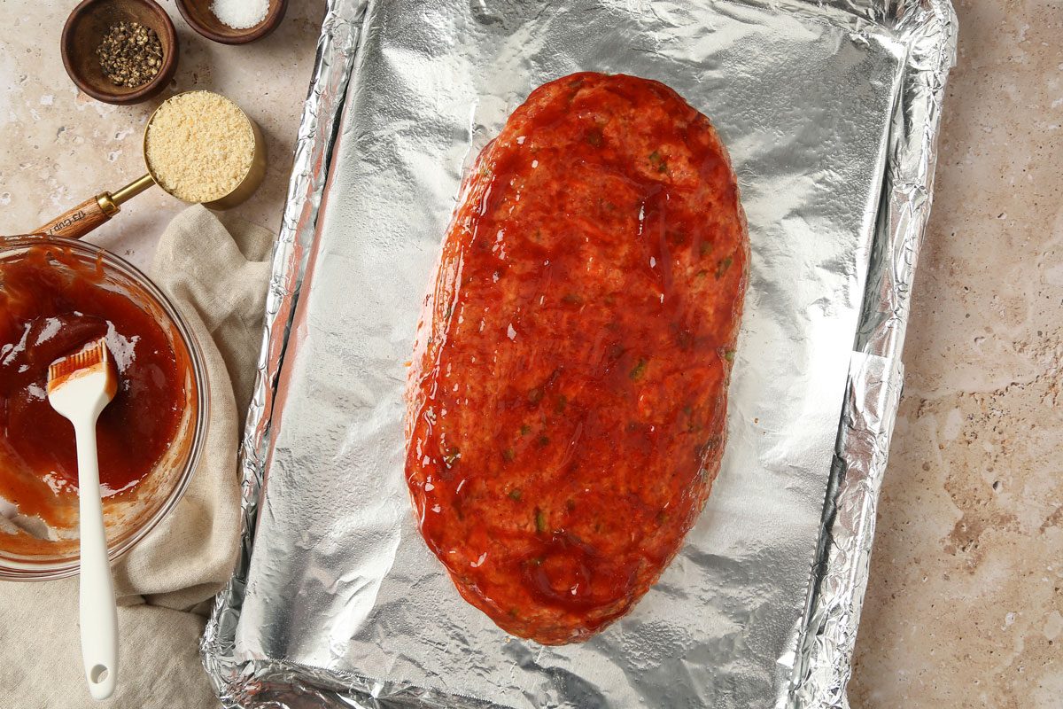 meat mixture shaped into a freeform loaf and brushed with sauce