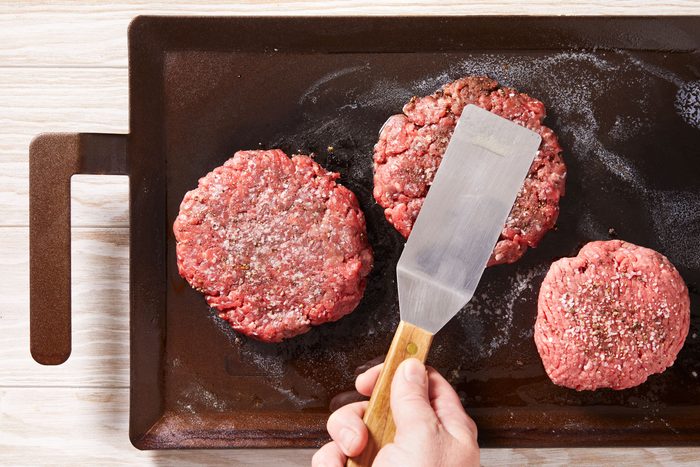 With a heavy metal spatula or burger press, flatten each patty to 1/4-in. thickness.