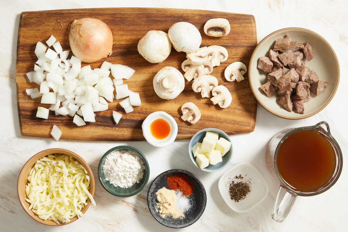 Onion Mushrooms Butter All-purpose flour Reduced-sodium beef broth Cooked roast beef Garlic powder Paprika Pepper Salt Hot pepper sauce Shredded mozzarella cheese